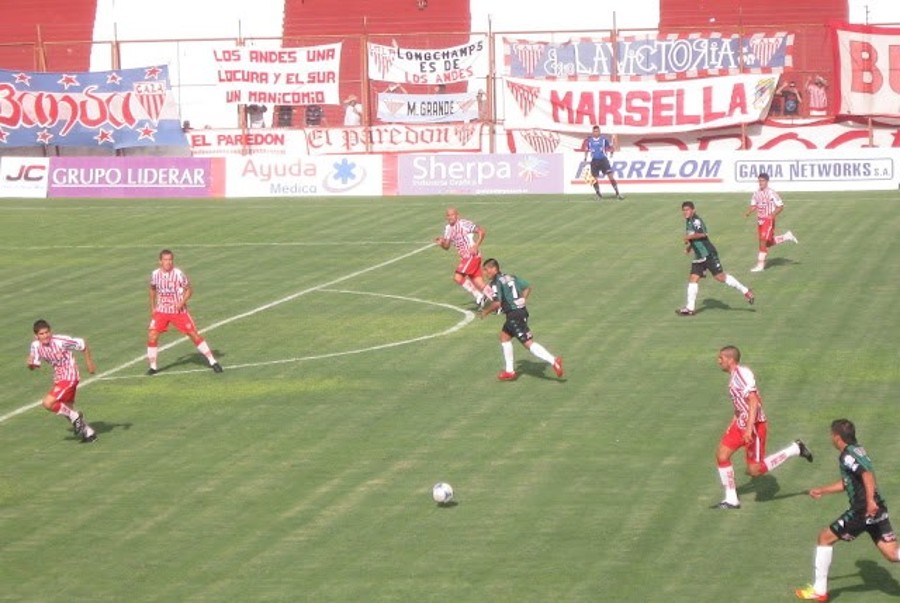 Argentine football club playing a match on green stadium.