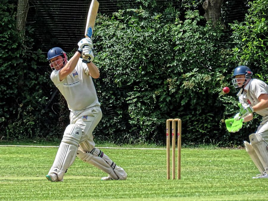 A batsman in white jersey playing a pull shot.
