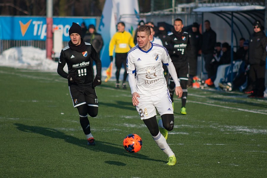 A Russian soccer player running with a soccer ball.